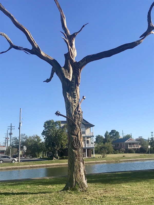 Tidbits of Life in New Orleans a dead tree that has been carved into a work of art.