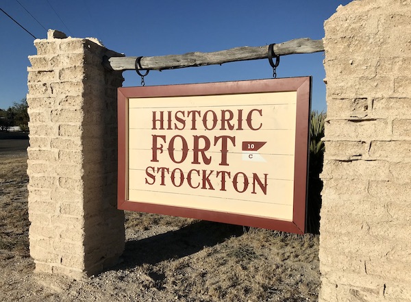 A sign hanging between two stone pillars announcing that you have arrived at historic Fort Stockton Texas