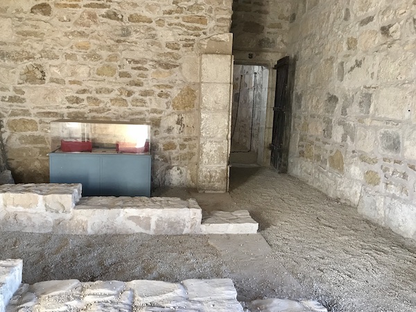 An interior room of the Fort Stockton Texas guard house with stone walls and dirt floor.