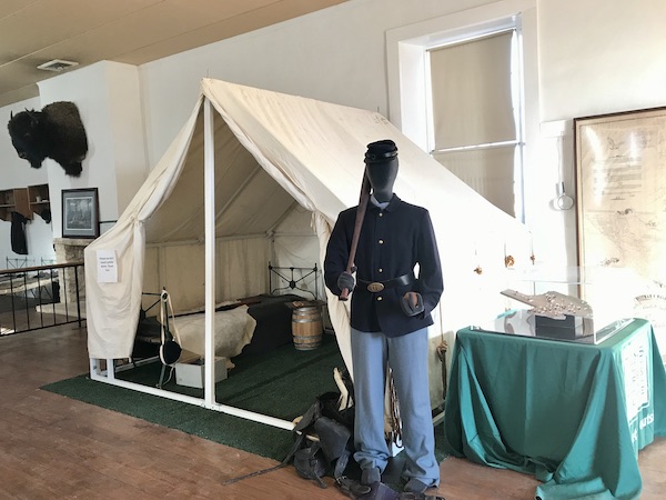 A soldier with a rifle standing by a tent at Fort Stockton Texas