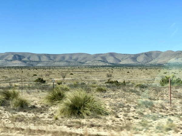 Dirt and grasses wirth mountains in the background at Big Bend National Park Texas