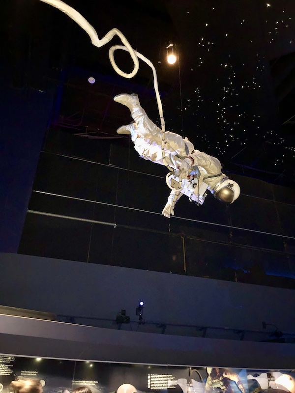 An astronaut appears to be floating in space tethered to a space craft at NASA Space Center Houston