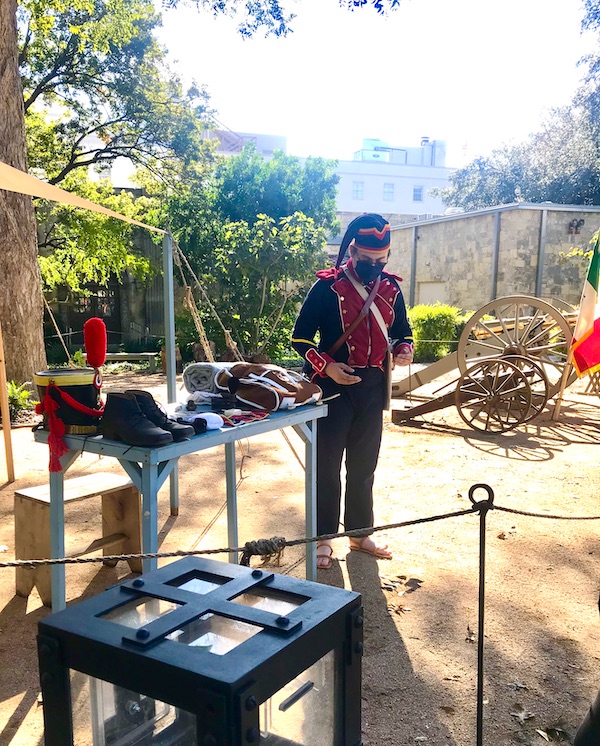 A man in uniform with sandals helps us Remember the Alamo
