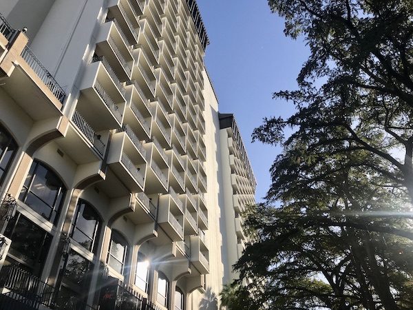 A white building with balconies along the San Antonio River Cruise