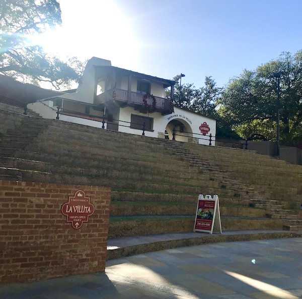 A white and brown building that is an inn along our San Antonio River Cruise