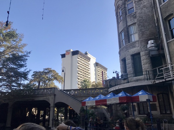 A white hotel building along our San Antonio River Cruise