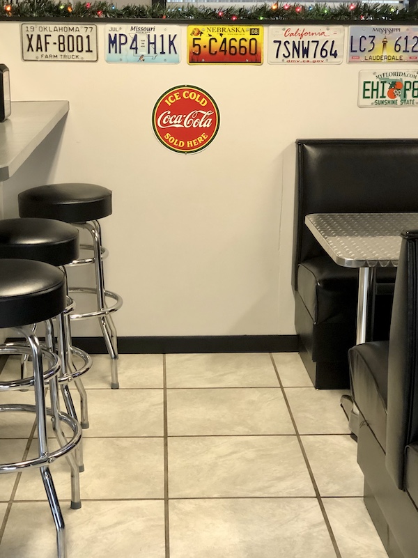A restaurant dining room with booths and bar stools in Sonora Texas