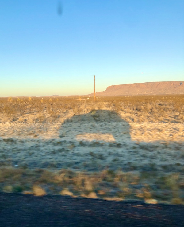 The shadow of an SUV on the side of the road at Terlingua Ranch Texas