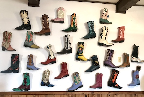 Cowboy boots in all colors are hung on a white wall at Terlingua Ranch Texas