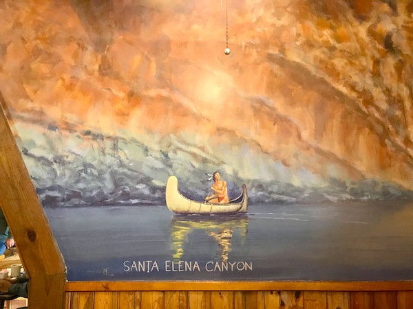A mural of an Indian rowing a canoe in a canyon lake at Terlingua Ranch Texas