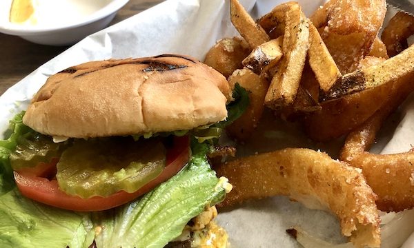 A large plate topped with a burger and fries sitting on deli paper at Terlingua Ranch Texas