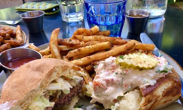 Another view of a cheeseburger half and lobster roll half with fries in The Pearl in San Antonio