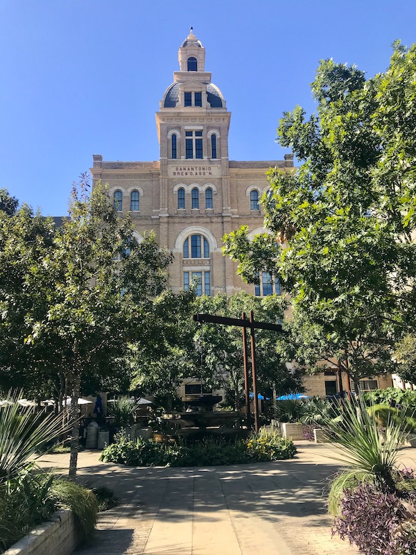 The front view of the Hotel Emma with landscaping and pavers in the foreground at The Pearl in San Antonio