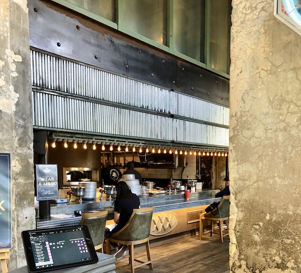 A long bar with corrugated metal above it at a restaurant in The Pearl in San Antonio