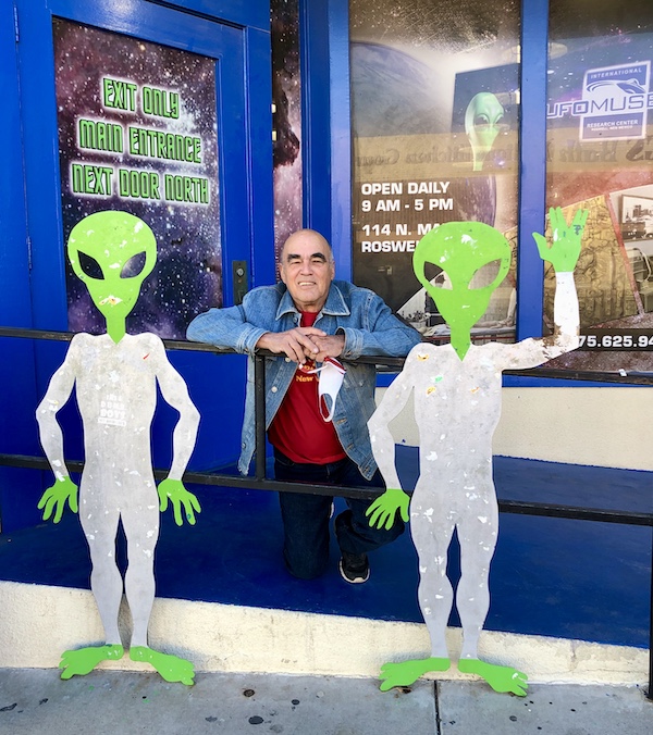 Two green men in white suits and a man in a jeans jacket prove that Aliens Abound in Roswell New Mexico
