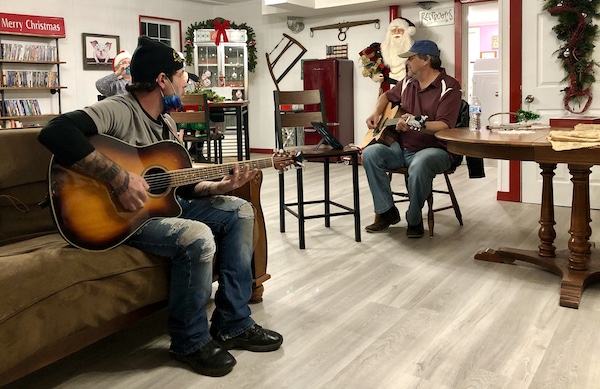 Two men playing guitar where Aliens Abound in Roswell New Mexico