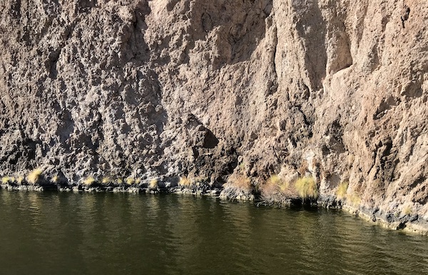 A large rocky expanse with different coloration and lake below seen along the #Locavores #WeLoveFood #RestaurantOwner #Foodies #Chef #FoodTruck #Cafe #Bistro #Eatery #TheTravelingLocavores #Recipes #FoodStories #Cooking #Wanderlust #Traveling