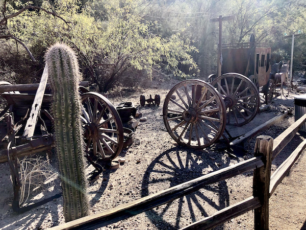 An old stagecoach and buckboard along with cactus along the Apache Trail Arizona