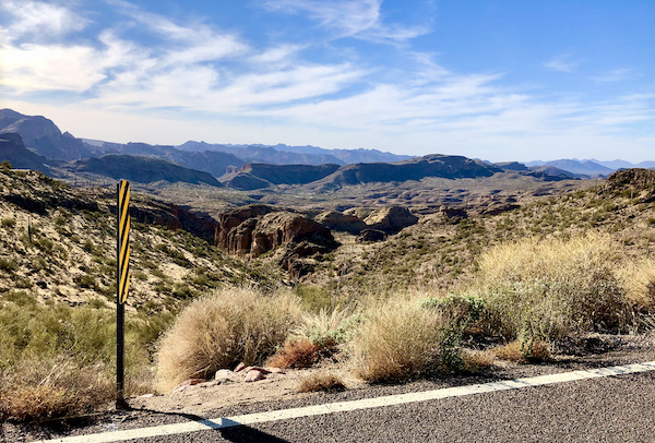Sage brush and mountains with blue sky and billowy white clouds along the Apache Trail Arizona