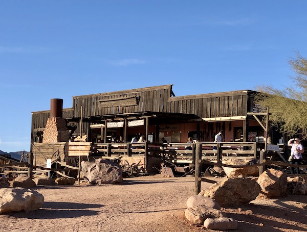 A dark brown building with wood fence along the Apache Trail Arizona