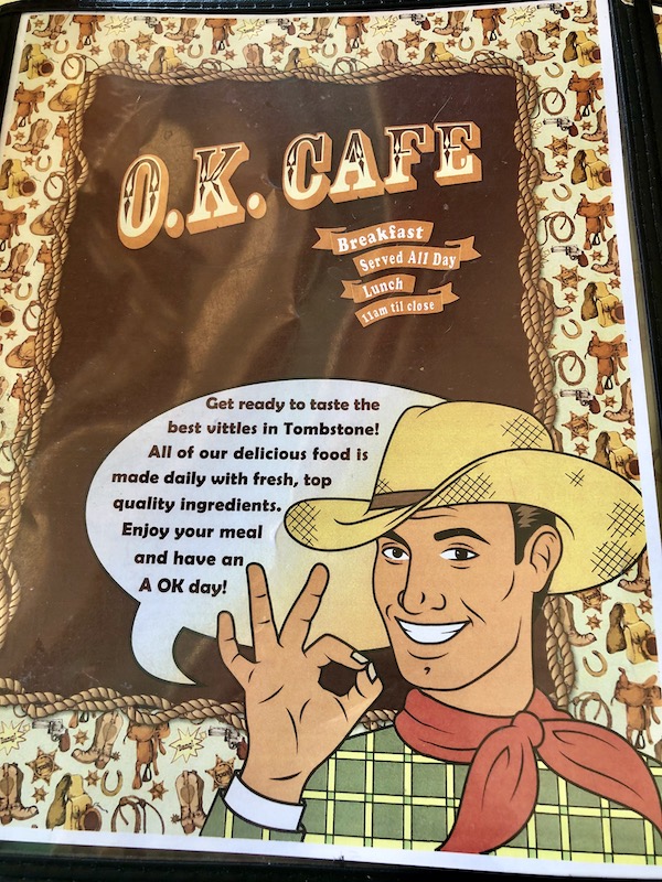 A menu cover with a cowboy telling you this place has the best food in Bisbee Tombstone and Boot Hill in Arizona