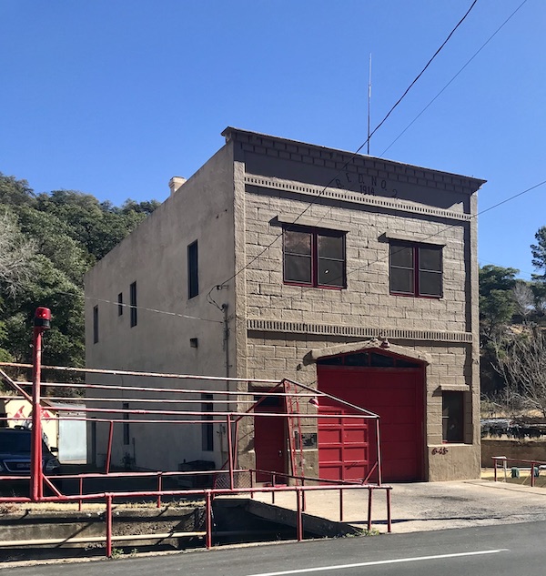 A freestanding gray building with a red garage door for a fire truck in Bisbee Tombstone and Boot Hill in Arizona