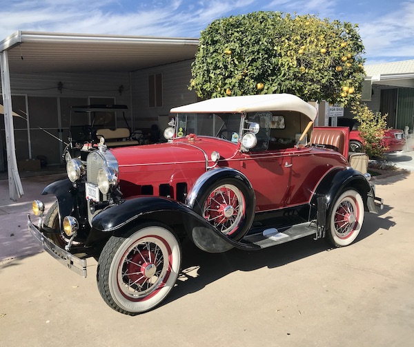 An antique red convertible with a rumble seat at Mesa Regal RV Resort
