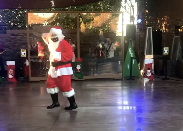A man in a Santa suit dancing at Mesa Regal RV Resort