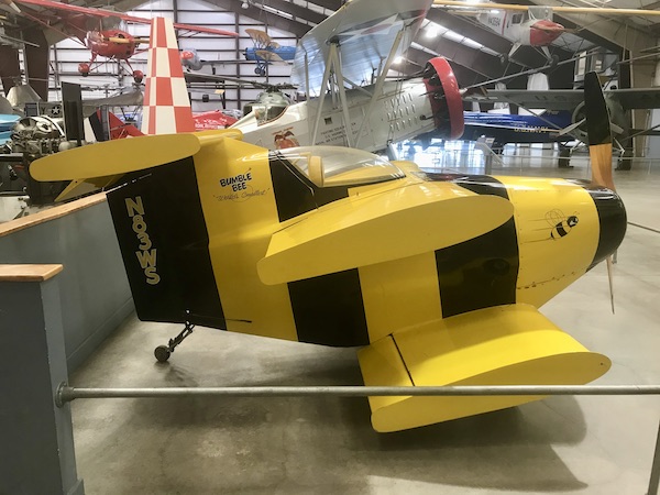 A small bright yellow and black plane at the Pima Air and Space Museum