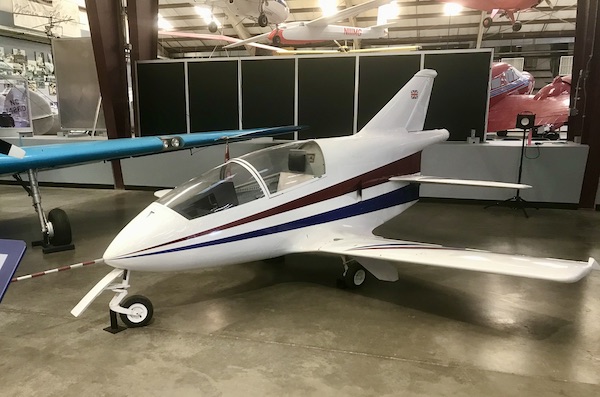 A small white glider plane with a burgundy and navy stripe at the Pima Air and Space Museum