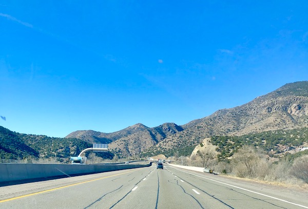 A highway with a mountainous view and deep blue sky driving from Santa Fe to Albuquerque New Mexico