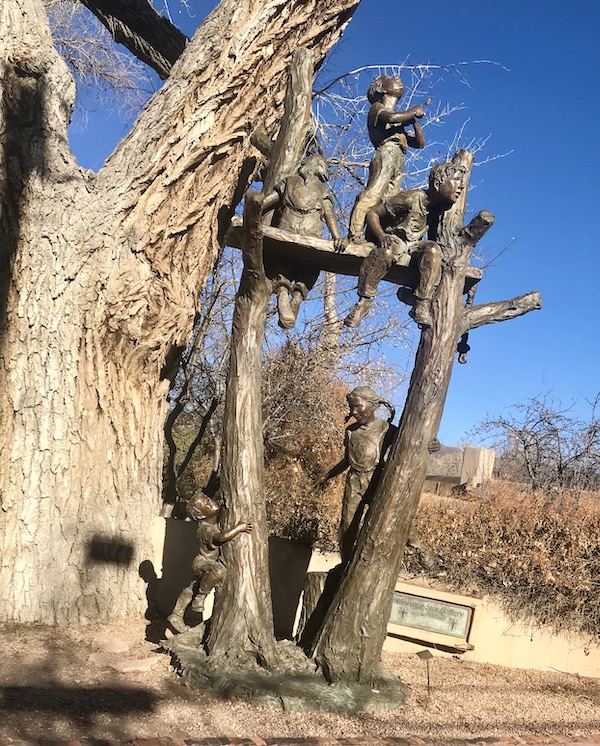 A playful bronze sculpture of children outside a gallery in Santa Fe