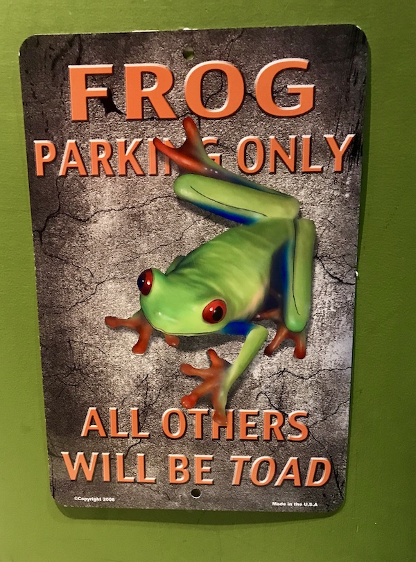 A tan and orange sign with a green frog at the Sonoran Desert Museum