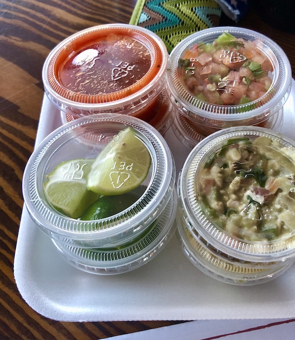 A white tray with plastic lidded containers of toppings for a hotdog on our way to the Sonoran Desert Museum