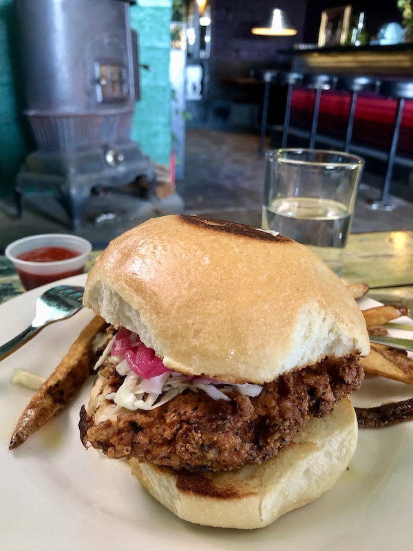 A fried chicken sandwich of a bun with pickled onions at The Waterstop Marfa Texas