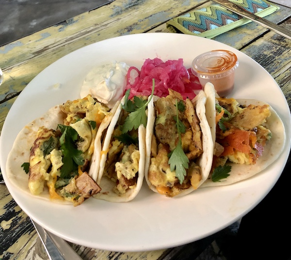 A white plate topped with four breakfast tacos at The Waterstop Marfa Texas