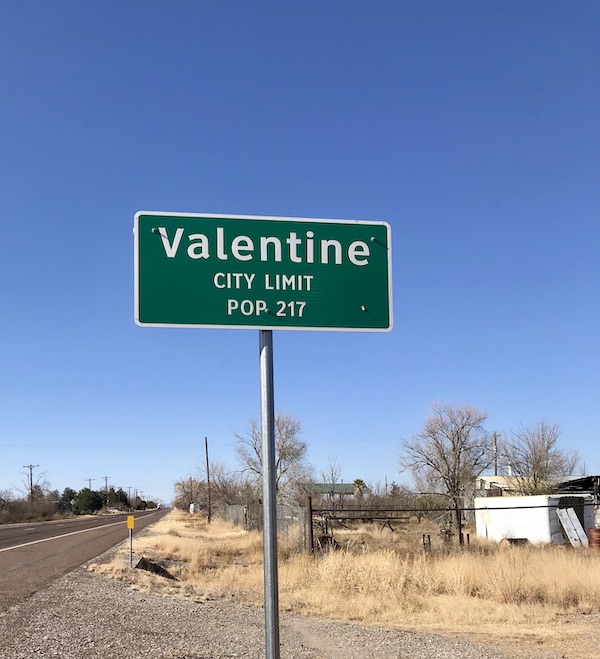 A green sign letting you know you are in the town of Valentine TX on the way home from The Waterstop Marfa Texas