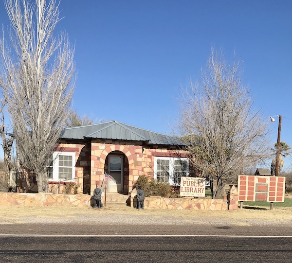 A brick house that is the Valentine TX library on our way home from The Waterstop Marfa Texas