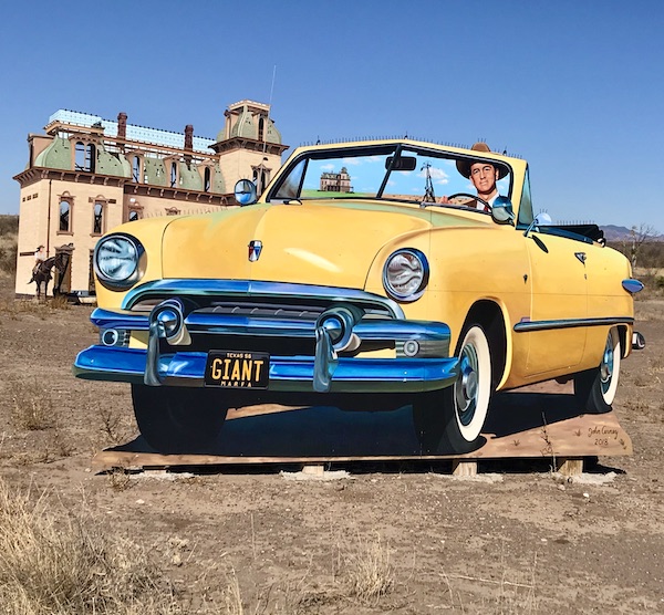 A cut out of a yellow vintage convertible just past The Waterstop Marfa Texas