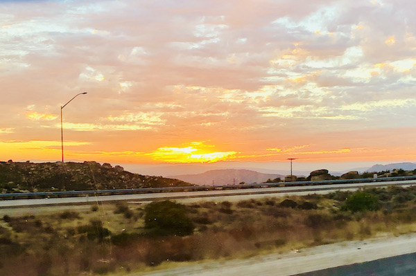California Here We Come, sun setting behind the mountains and creating a colorful sky.