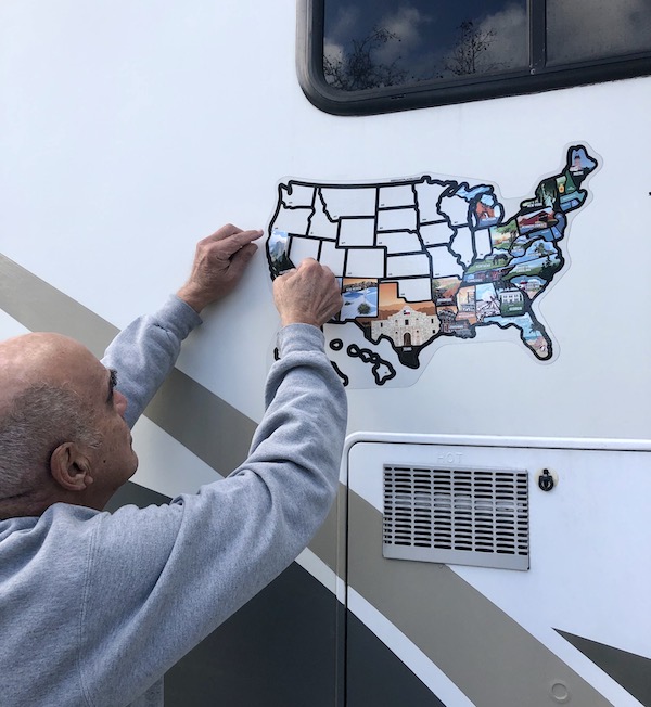 California Here We Come, a man putting a state sticker on a map of America.