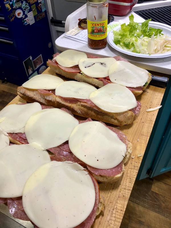 A large wood board topped with 4 sandwiches eaten en route Coast to Coast We Did It!