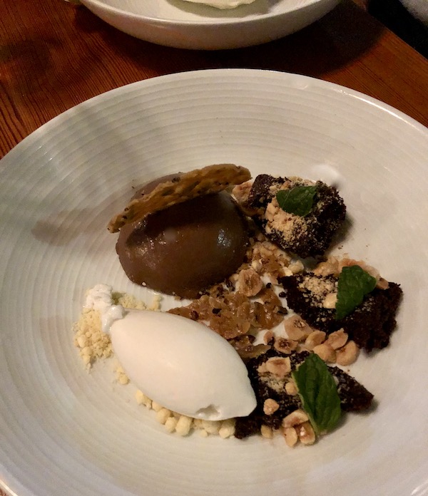A large white plate topped with chocolate, nuts and vanilla ice cream eaten en route Coast to Coast We Did It!