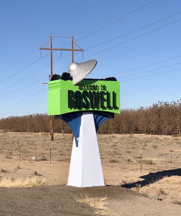 A lime green and white sign welcoming you to Roswell NM en route Coast to Coast We Did It!