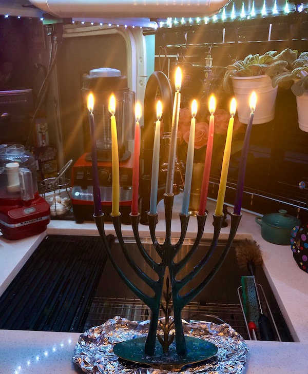 A completely lit 9 candle candelabra with colored candles Coast to Coast We Did It!