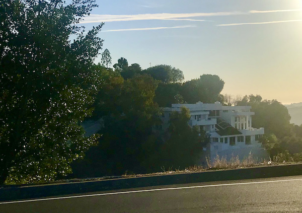 A large white mansion nestled in the trees in Opulent Beverly Hills California