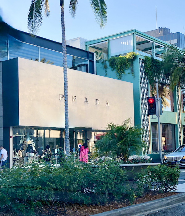 A street lined with posh stores and landscaping in Opulent Beverly Hills California