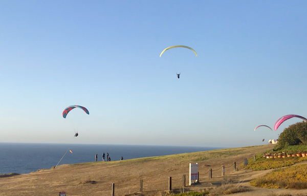 Several hang gliders above the beach in San Diego California