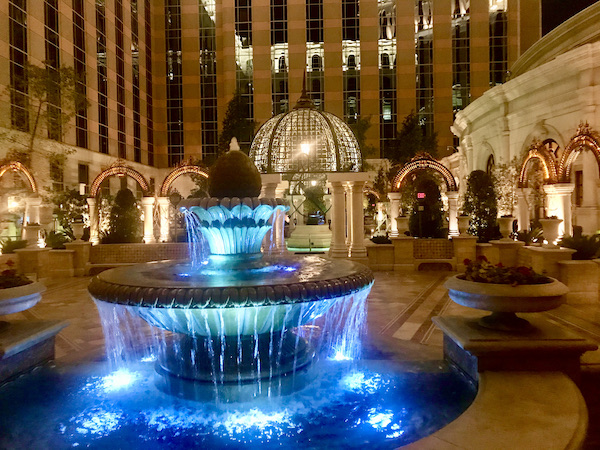 A fountain lit with blue lights and a domed gazebo with white lights at the Venetian Hotel home to Thomas Keller's Bouchon Las Vegas