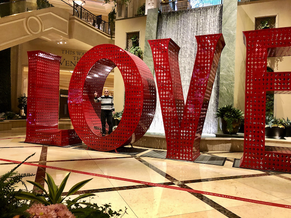 Huge red letters LOVE on a marble floor with a man in the O at the Venetian Hotel home of Thomas Keller's Bouchon Las Vegas